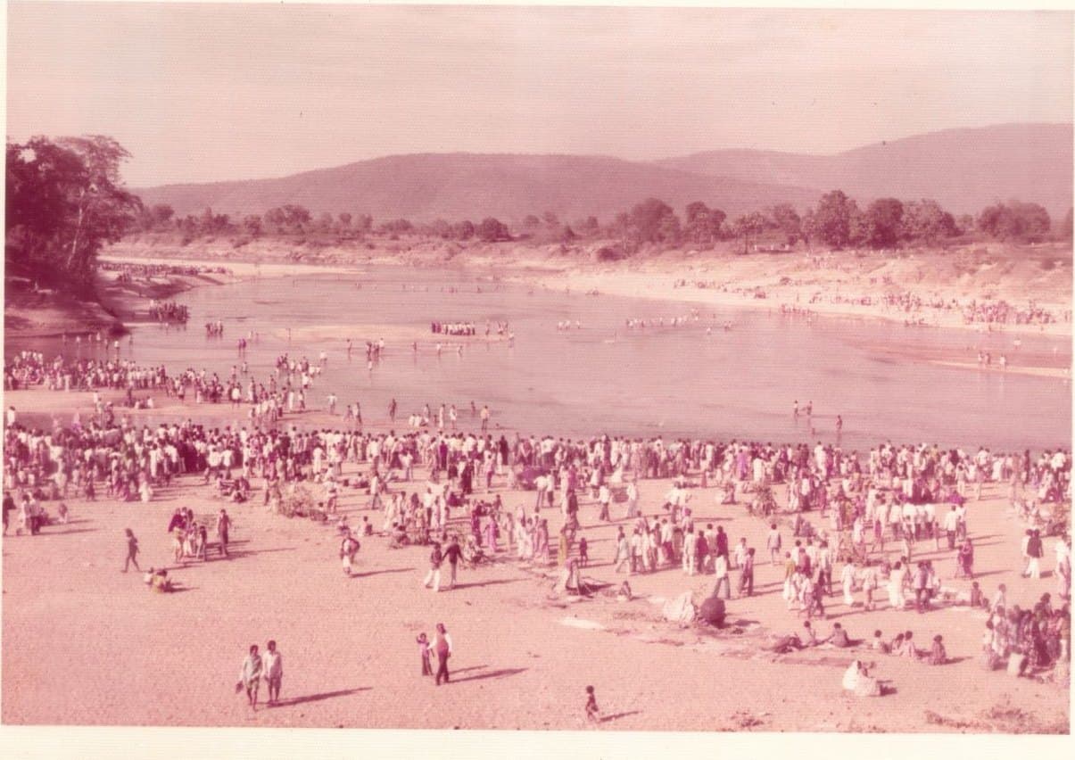An archive photograph of a crowd gathered along a river bank.